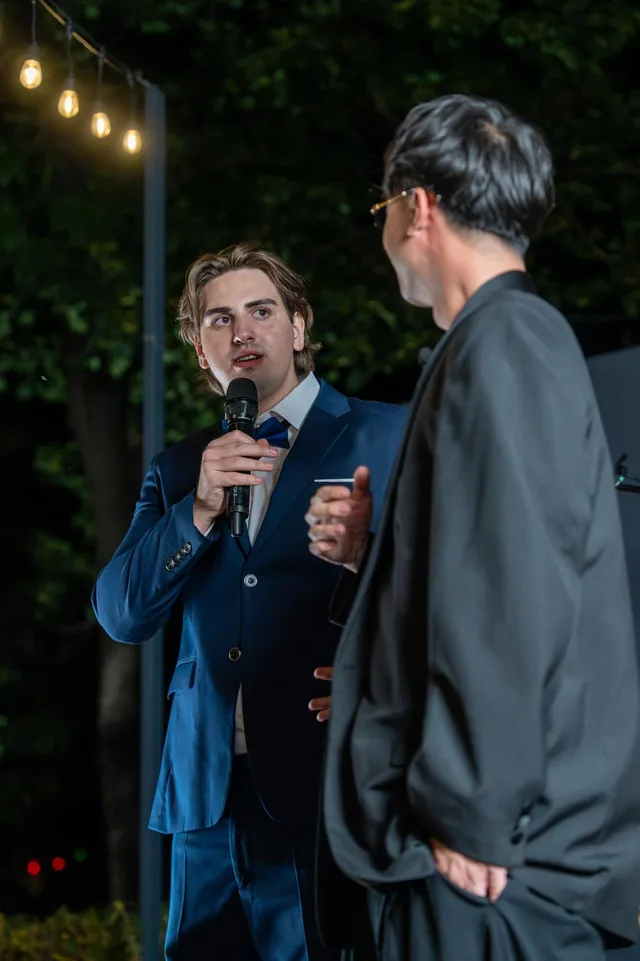 A speaker and host on stage at an Elite Media United event